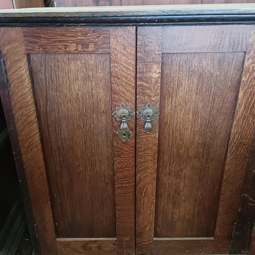 23 - An oak cupboard, having four cupboard doors, 153 cm wide<br /><br />Please note collection is from T...