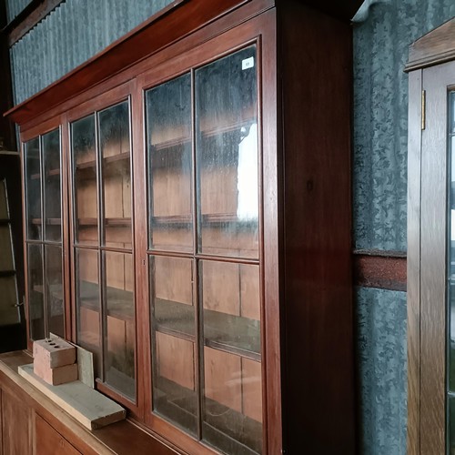 69 - A 19th century mahogany bookcase cabinet, the top with three glazed doors, the base with two drawer ... 