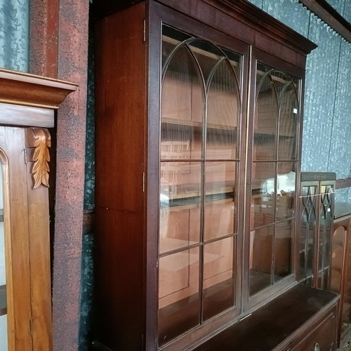 77 - A George III mahogany secretaire bookcase, the top with two glazed doors, above a fitted drawer, and... 