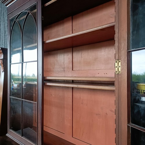 77 - A George III mahogany secretaire bookcase, the top with two glazed doors, above a fitted drawer, and... 