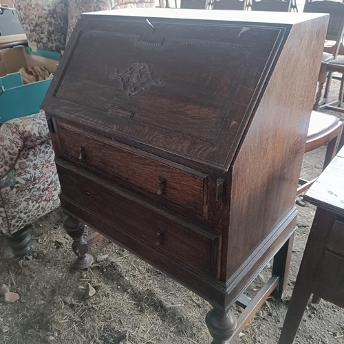 89 - An oak bureau, an armchair, assorted music scores, and an oak lowboy, 77 cmPlease note collection is... 