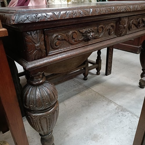 135 - An early 20th century oak side table, with two frieze drawers, on bulbous supports, 127 cm widePleas... 