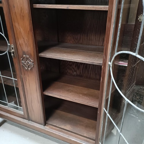 138 - An early 20th century oak bookcase, with leaded glazed doors, 107 cm widePlease note collection is f... 