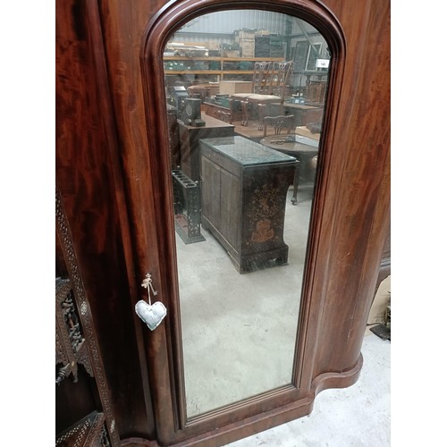 140 - A Victorian mahogany serpentine wardrobe, with a mirrored door, the interior with drawers and slides... 