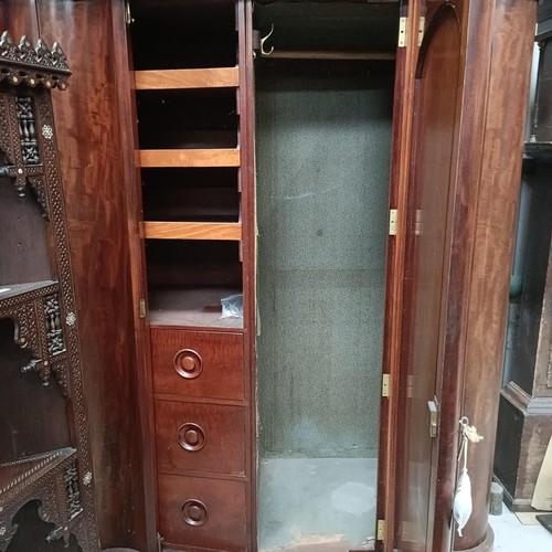 140 - A Victorian mahogany serpentine wardrobe, with a mirrored door, the interior with drawers and slides... 