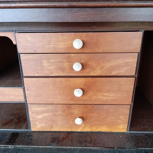 77 - A George III mahogany secretaire bookcase, the top with two glazed doors, above a fitted drawer, and... 