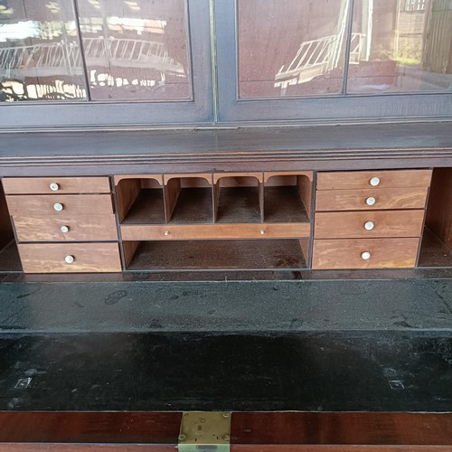 77 - A George III mahogany secretaire bookcase, the top with two glazed doors, above a fitted drawer, and... 