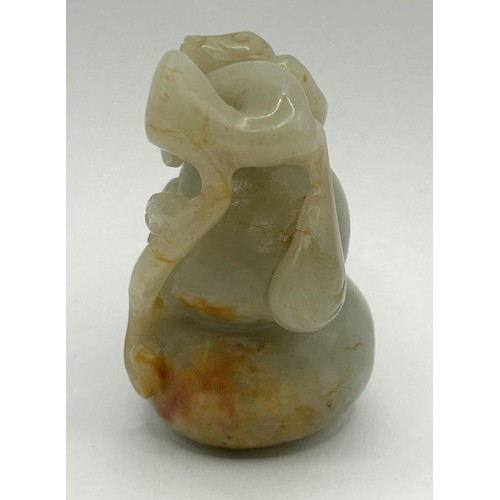 815 - A Chinese carved green stone figure of a monkey on a gourd, 6 cm wide