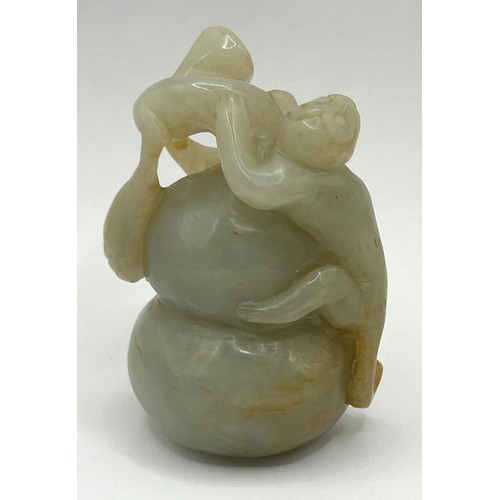 815 - A Chinese carved green stone figure of a monkey on a gourd, 6 cm wide