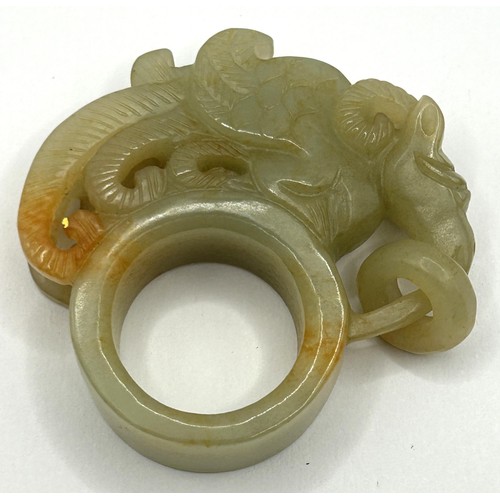 821 - A Chinese carved green stone ring, decorated mythical beast, 6 cm wide