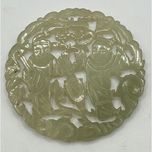 830 - A Chinese pale hardstone pierced plaque, decorated figures, 5 cm diameter