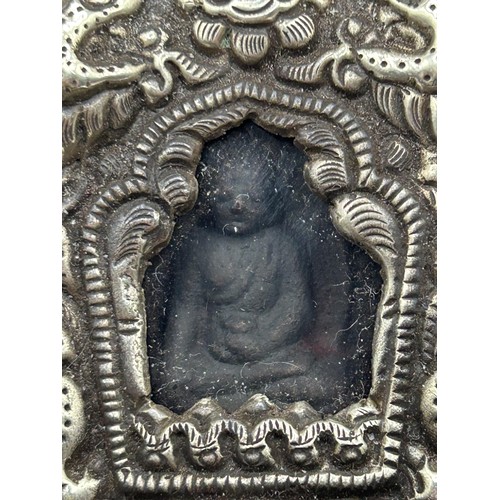 855 - A Chinese silver coloured metal reliquary, with a glass panel inset with buddha, in an embroidered c... 