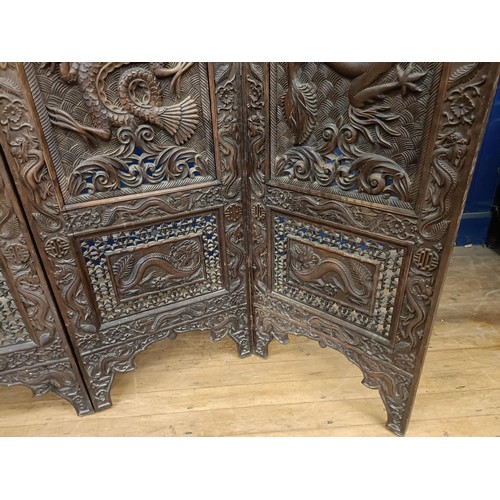 878 - A Chinese carved four fold screen, decorated dragons and flowers, each panel 190 cm high x 50 cm wid... 