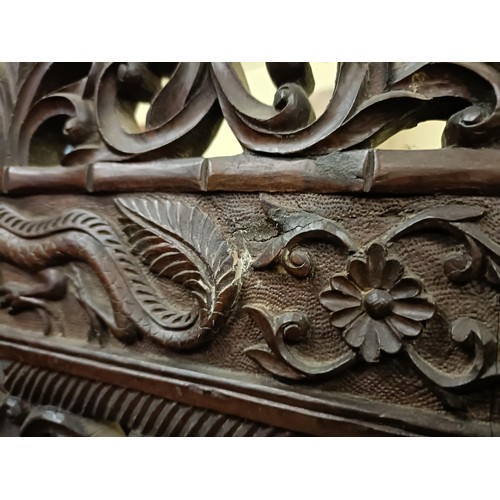 878 - A Chinese carved four fold screen, decorated dragons and flowers, each panel 190 cm high x 50 cm wid... 