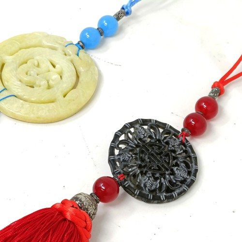 911 - A Chinese hardstone carved plaque, 8 cm diameter, with attached tassel, another, 5 cm diameter (2)