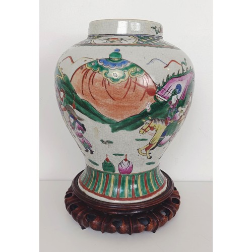 912 - A Chinese vase and cover, decorated figures, on a carved wooden stand, 53 cm high