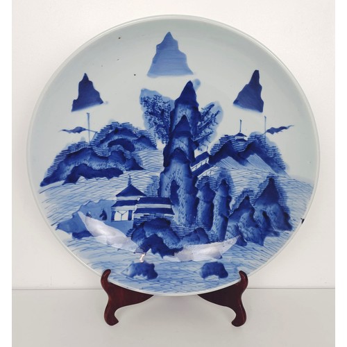 917 - A Japanese blue and white dish, decorated a landscape, 41 cm diameter