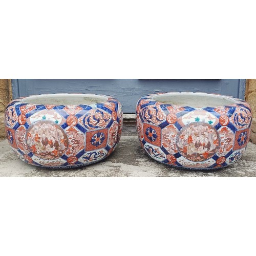 930 - A large pair of Japanese Imari planters, with various cartouches decorated figures, character mark t... 