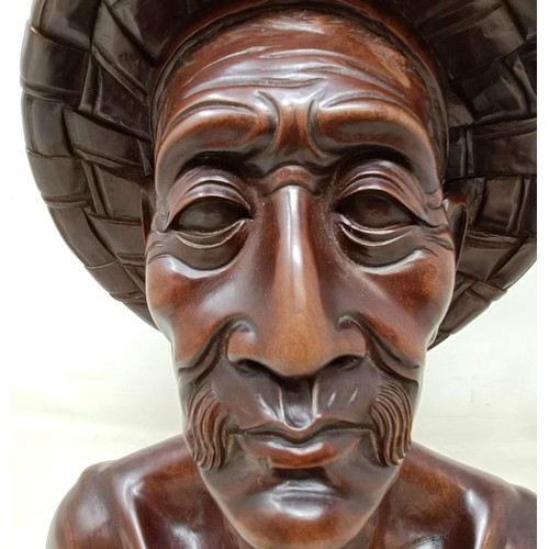 940 - A Balinese carved bust portrait, of a man, 35 cm high