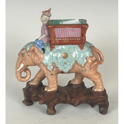 835 - A porcelain figure of an elephant with a rider, on a carved wooden base, 14.5 cm high