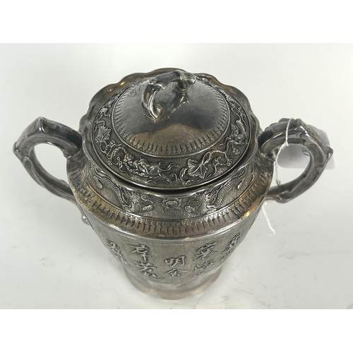 850 - A Chinese silver coloured metal two handle cup and cover, with embossed dragons, foliage, and Chines... 