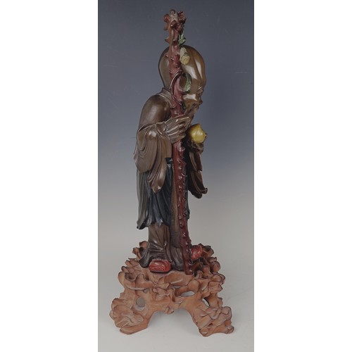 945 - A Chinese carved and painted figure, of a sage, on a pierced base, 48 cm high