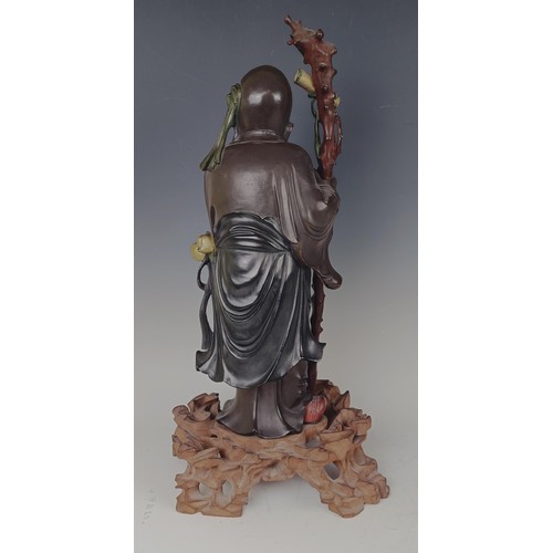 945 - A Chinese carved and painted figure, of a sage, on a pierced base, 48 cm high