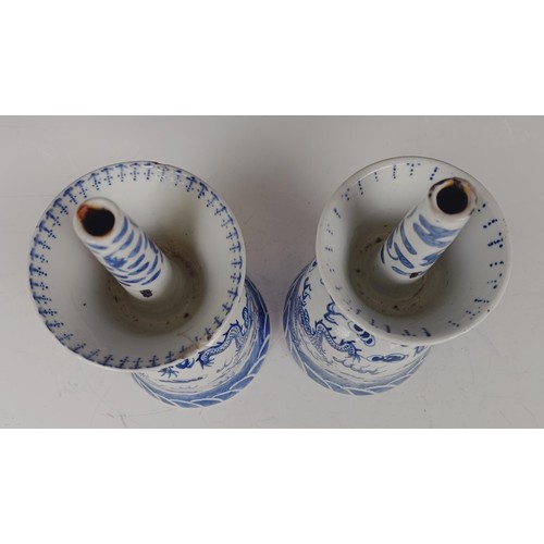 964 - A pair of Chinese blue and white oil lamps, decorated dragons chasing a flaming pearl in underglaze ... 