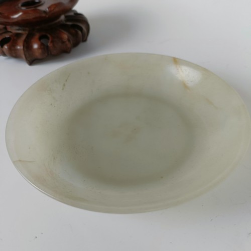 800 - A Chinese jade bowl, of shallow form, bearing a Chia-Ching (1796-1820) incised four character mark t... 