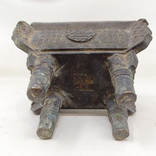 860 - A Chinese bronze censer, decorated figures and characters, on four legs, 14 cm wide