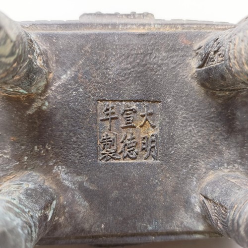 860 - A Chinese bronze censer, decorated figures and characters, on four legs, 14 cm wide