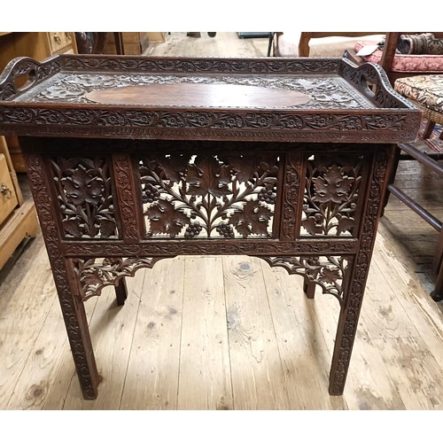 877 - A carved Indian tray top folding table, 61 cm wide