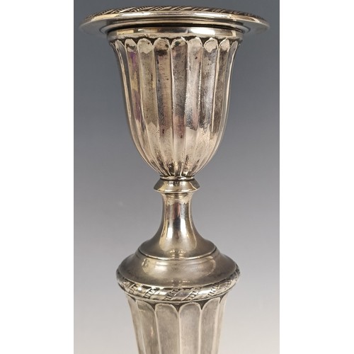 7 - A pair of Victorian silver candlesticks, with fluted decoration, London 1885, loaded 31 cm high,