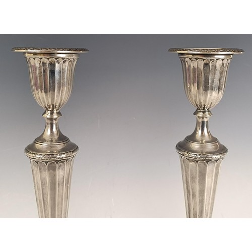 7 - A pair of Victorian silver candlesticks, with fluted decoration, London 1885, loaded 31 cm high,