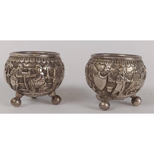 73 - A pair of Persian silver coloured metal salts, with embossed decoration, lacking liners (2)