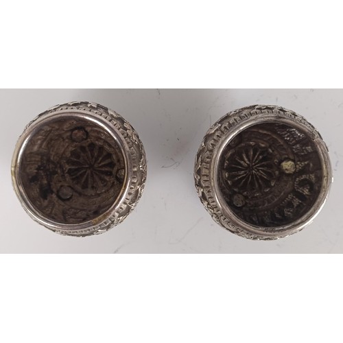 73 - A pair of Persian silver coloured metal salts, with embossed decoration, lacking liners (2)