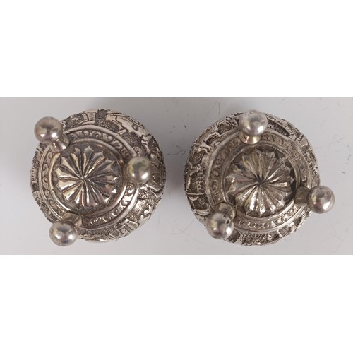 73 - A pair of Persian silver coloured metal salts, with embossed decoration, lacking liners (2)