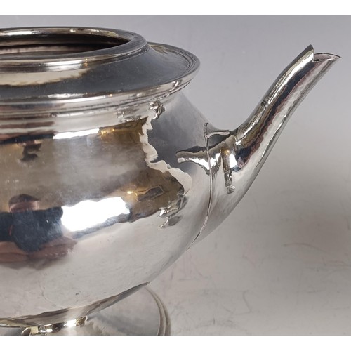 125 - Omar Ramsden, (1873-1939), A George V silver three piece pedestal tea set, comprising a teapot, milk... 