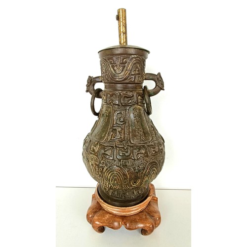 962 - A Chinese bronze vase, with ring handles, 30 cm high, on a wooden base, converted to a lamp