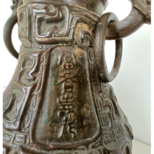 962 - A Chinese bronze vase, with ring handles, 30 cm high, on a wooden base, converted to a lamp