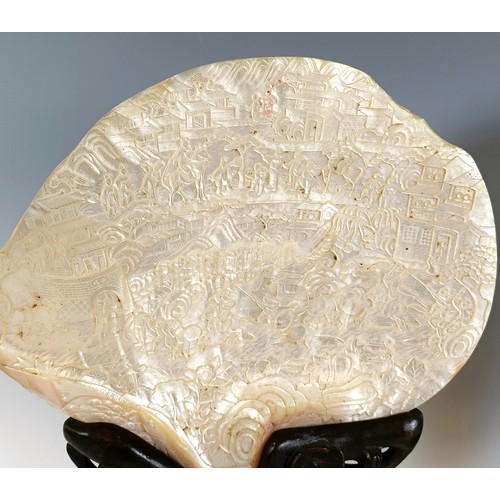 932 - A large pair of Chinese mother of pearl bi-discs, carved figures, horses, dwellings and fish, on car... 