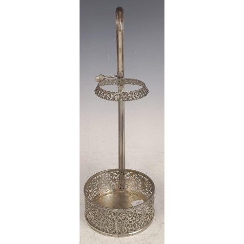 143 - A Continental silver coloured metal wine bottle holder, with a reeded handle and pierced decoration,... 