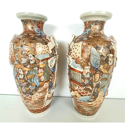 951 - A pair of Japanese vases, decorated figures, highlighted in gilt, 32 cm high (2)