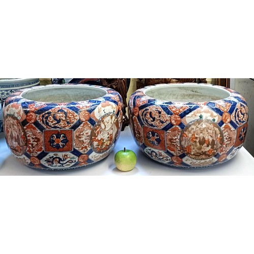 930 - A large pair of Japanese Imari planters, with various cartouches decorated figures, character mark t... 