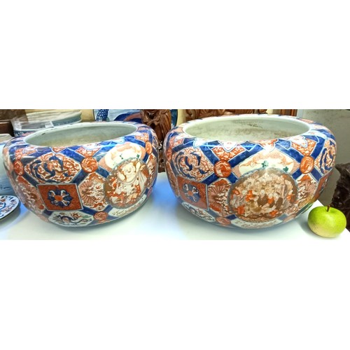 930 - A large pair of Japanese Imari planters, with various cartouches decorated figures, character mark t... 