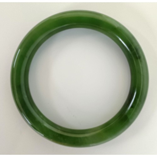 984 - A Chinese green jade bangle, 8 cm diameter