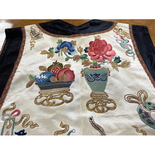 890 - A Chinese silk embroidered sleeveless jacket, decorated vases, flowers and other motifs