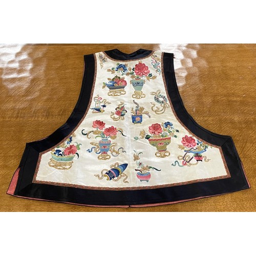 890 - A Chinese silk embroidered sleeveless jacket, decorated vases, flowers and other motifs