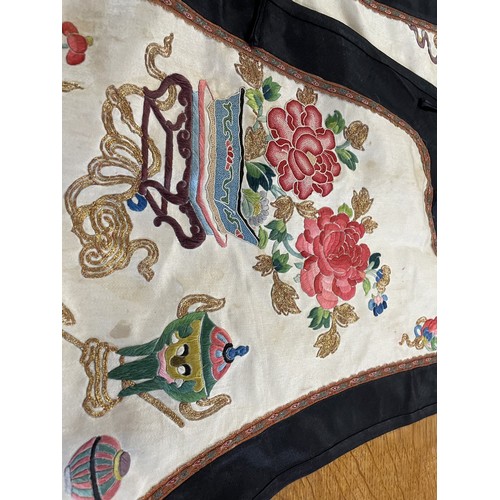 890 - A Chinese silk embroidered sleeveless jacket, decorated vases, flowers and other motifs