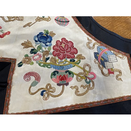 890 - A Chinese silk embroidered sleeveless jacket, decorated vases, flowers and other motifs